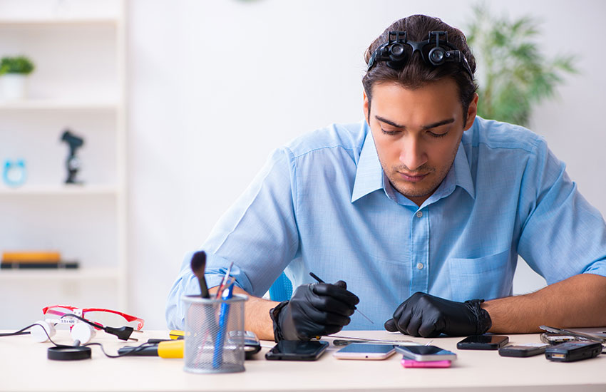 Young Male Technician Repairing Mobile Phone