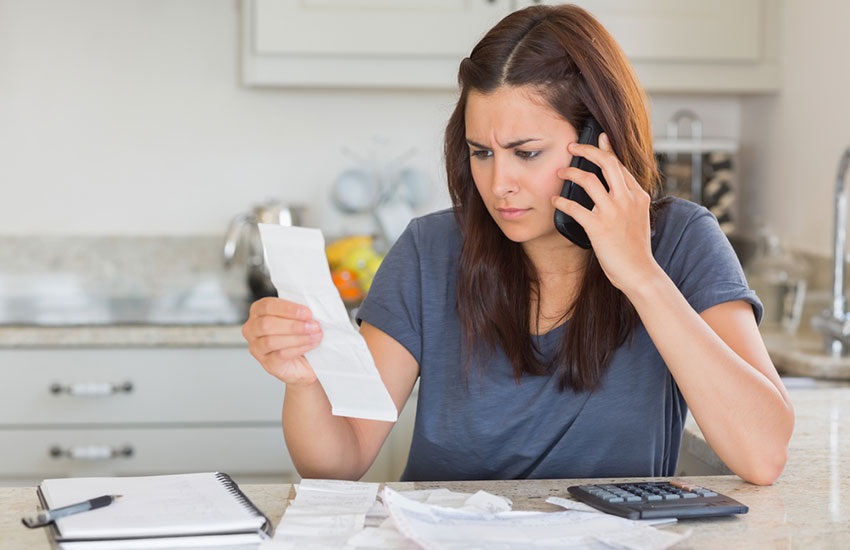 Woman Calling While Calculating Bills