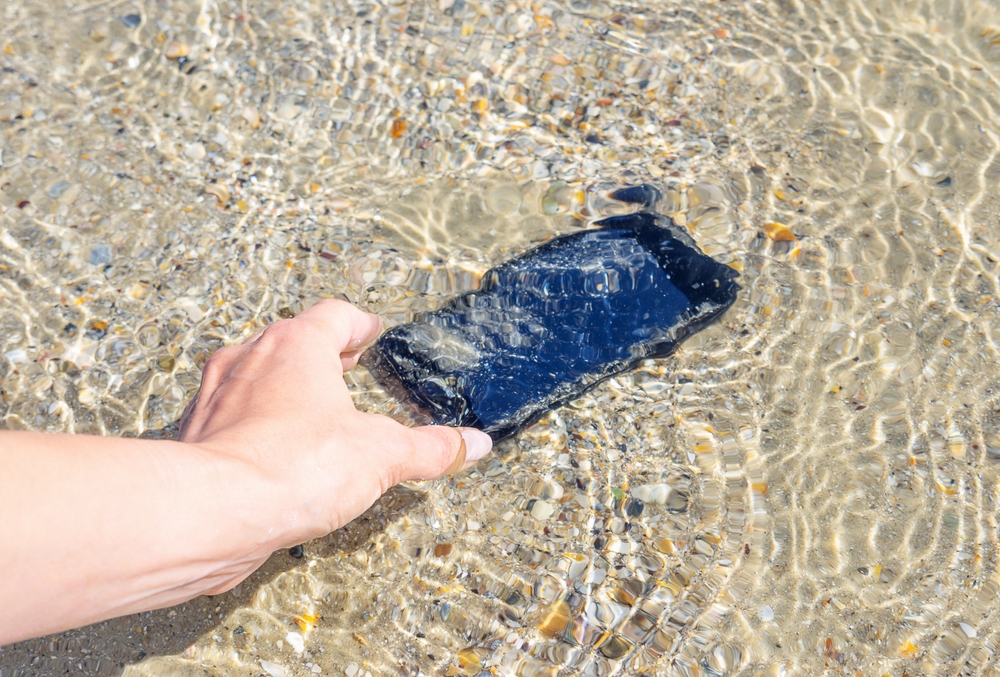 woman removing smartphone from water