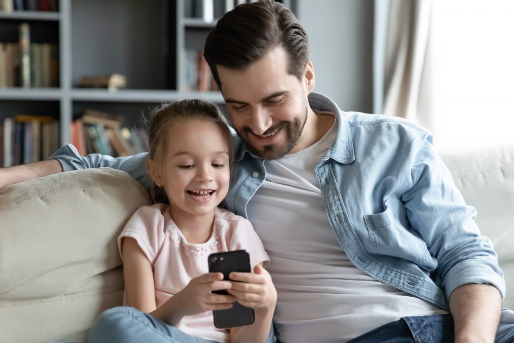 Father and daughter looking at phone